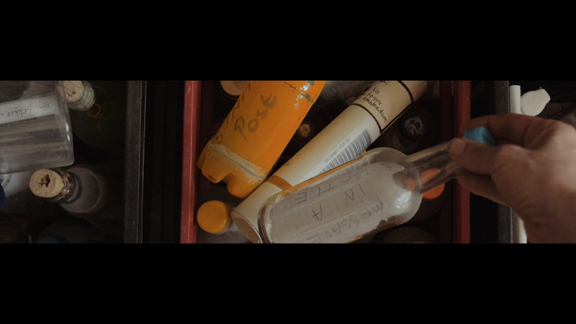 Still from Strophe showing messages in bottles