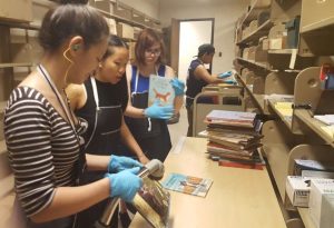 Student employees vacuum and shelve incoming books