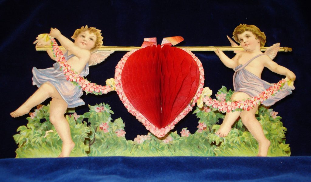 19th-century valentine wiht two cupids carrying large heart between them